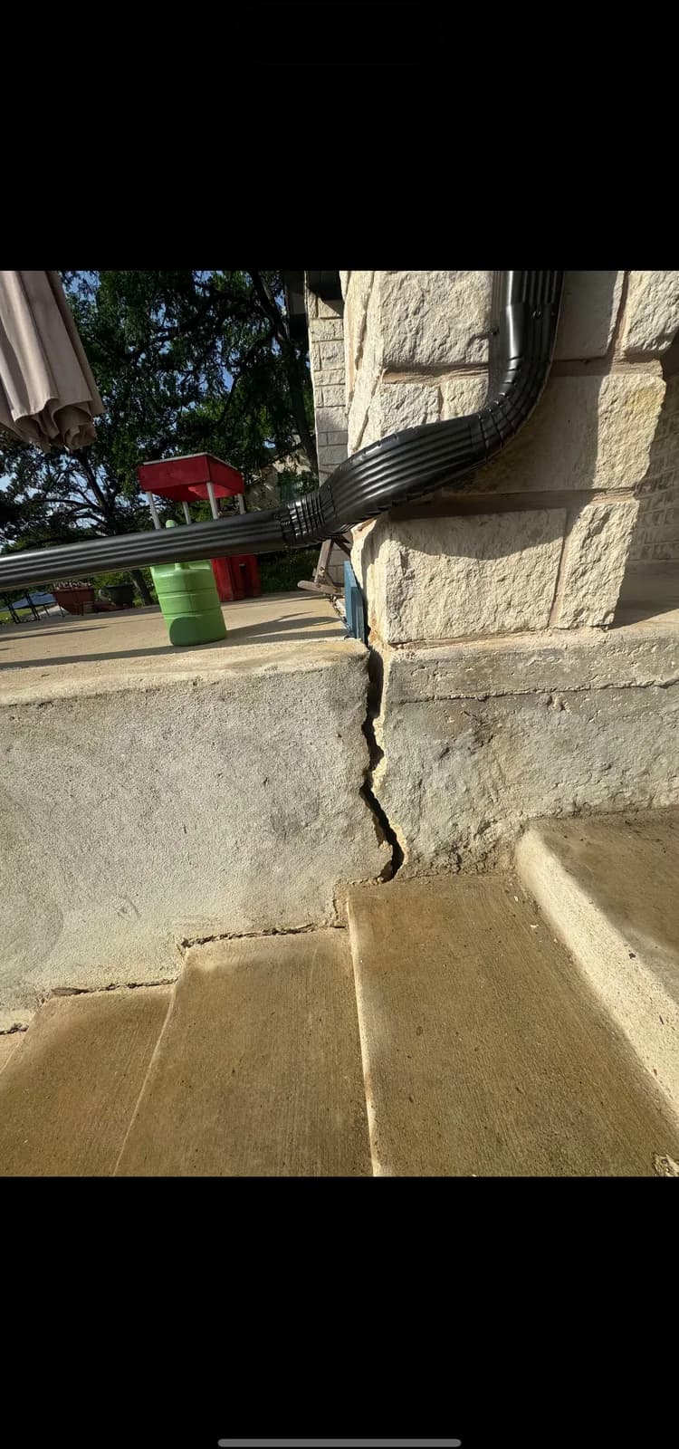 Close up of a stair step crack running through brick mortar joints on the exterior of a house