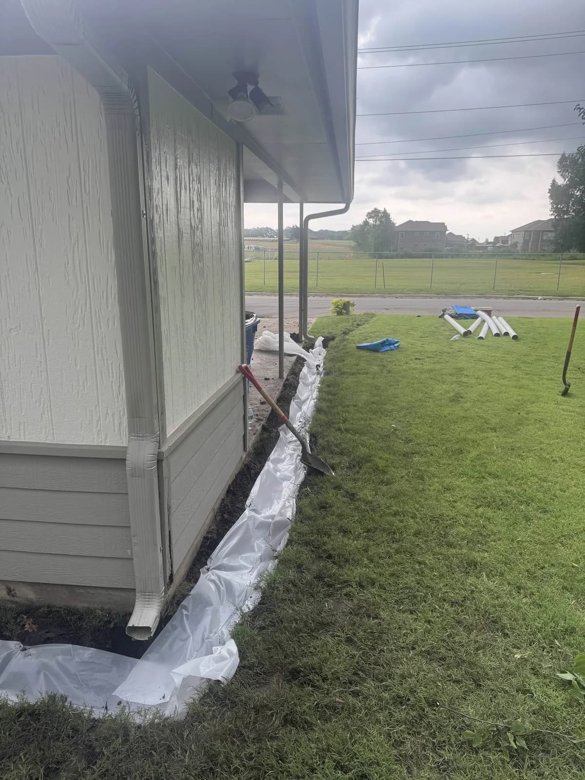 French drain trench following the foundation line under the eaves of a single story home